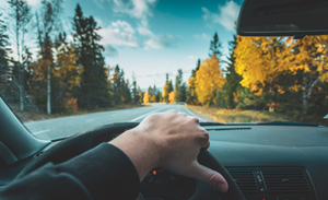 man with hand on steering wheel